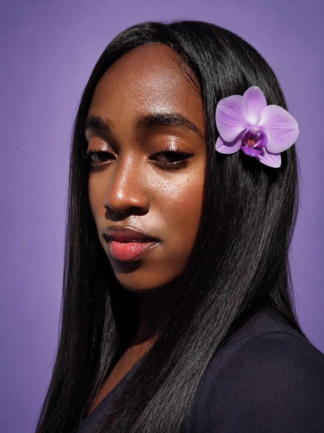 Portrait of Sisanda Ngcakani, the artist behind Naomi Artworks, with a purple orchid in her hair